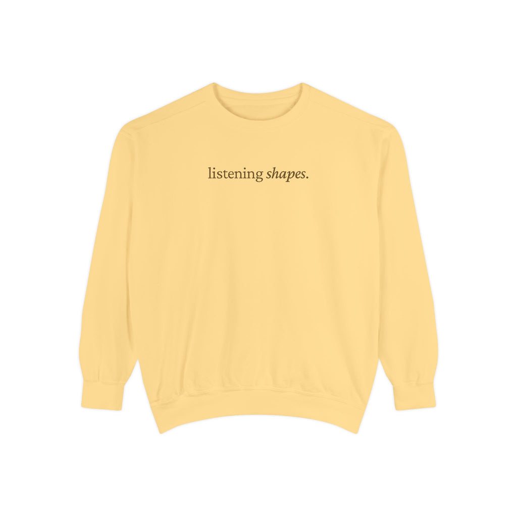 Yellow sweatshirt with 'listening shapes' text on a white background