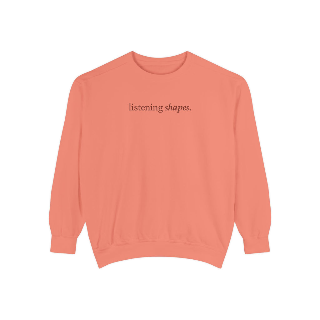 Coral sweatshirt with 'listening shapes' text on a white background